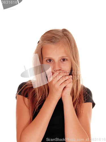 Image of Young girl holding hands over mouth.