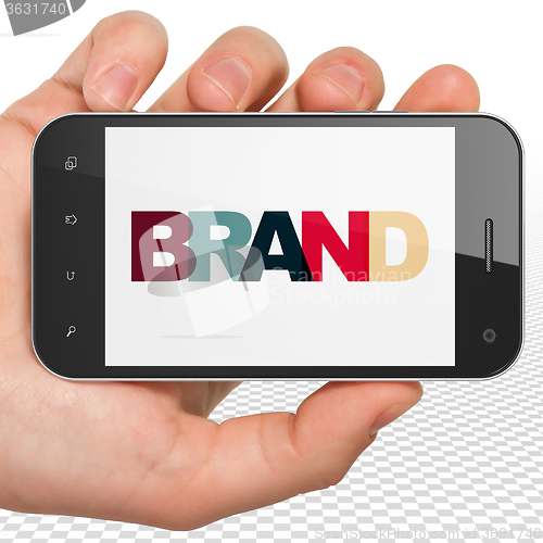Image of Marketing concept: Hand Holding Smartphone with Brand on  display