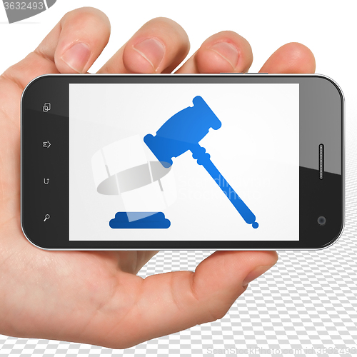 Image of Law concept: Hand Holding Smartphone with Gavel on display