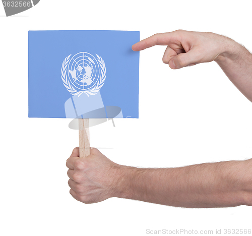 Image of Hand holding small card - Flag of the UN