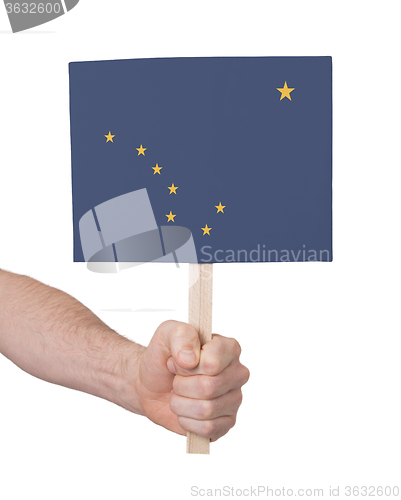 Image of Hand holding small card - Flag of Alaska