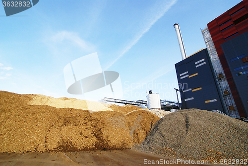 Image of bio power plant with storage of wooden fuel (biomass) against bl