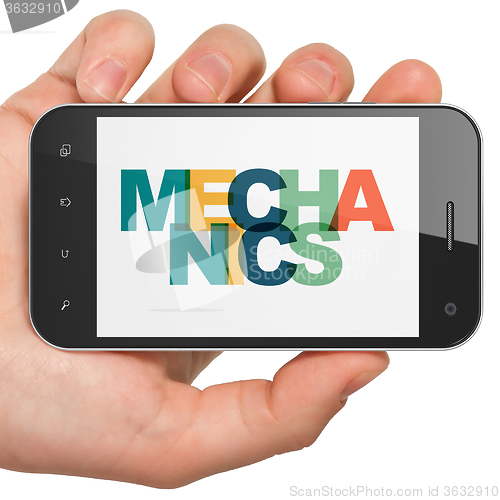 Image of Science concept: Hand Holding Smartphone with Mechanics on  disp