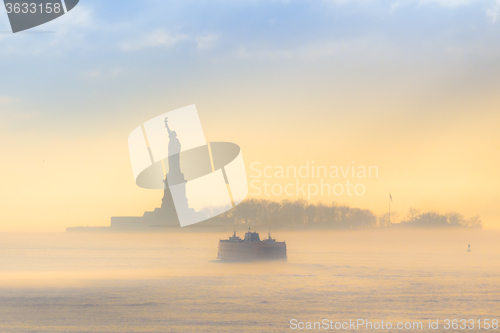 Image of Staten Island Ferry cruises past Statue of Liberty.