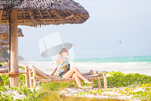 Image of Woman sunbathing on tropical beach.