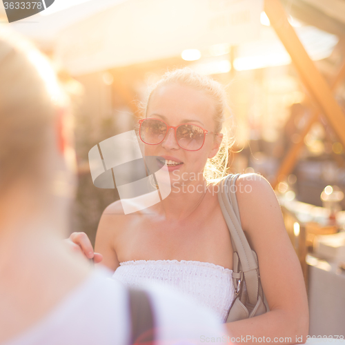 Image of Female friends enjoying a conversation on market.