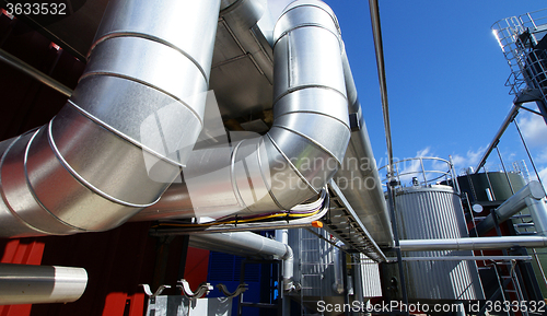 Image of industrial pipelines on pipe-bridge against blue sky 