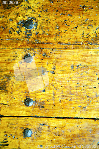 Image of metal nail  stripped paint in the brown     yellow  