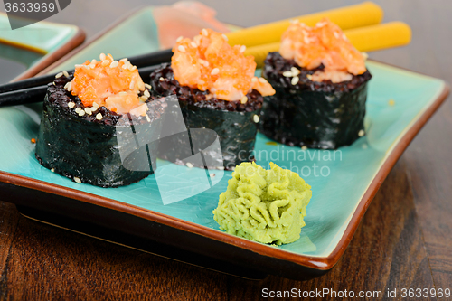 Image of Baked sushi rolls served on blue plate