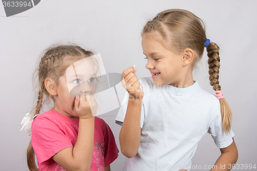 Image of Four-year girl with horror looks at the lost tooth in his hand a six-year girl