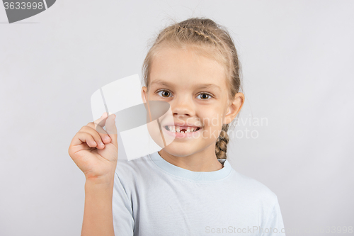 Image of The girl proudly showing her fallen baby tooth