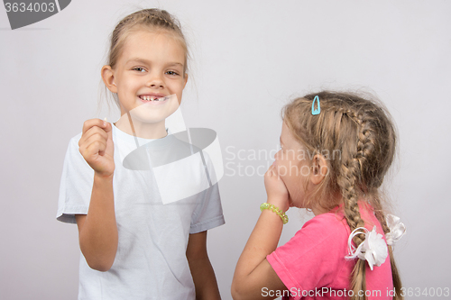 Image of Six year old girl showing her teeth her younger sister