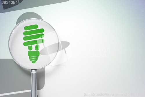 Image of Finance concept:  Energy Saving Lamp with optical glass on digital background