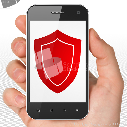 Image of Safety concept: Hand Holding Smartphone with Shield on display