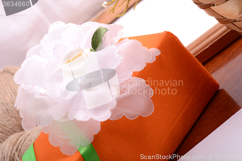 Image of Christmas gift box and empty wooden frame on wooden table