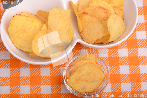 Image of chips and peeled potato on a white plate