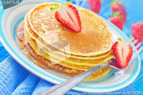 Image of pancakes on plate and fresh strawberries