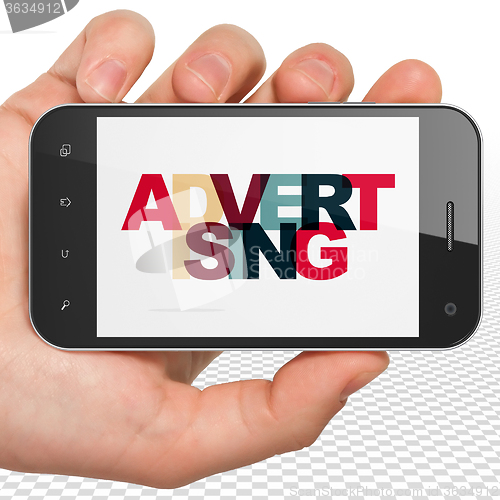 Image of Marketing concept: Hand Holding Smartphone with Advertising on  display