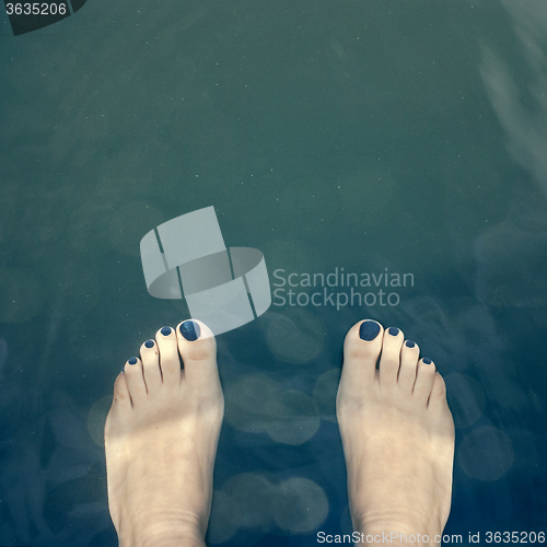 Image of Bare feet over the water