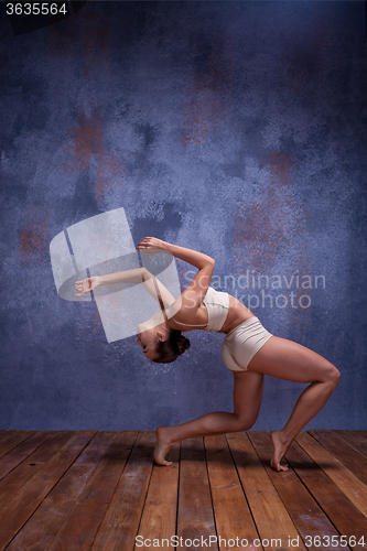 Image of Young beautiful dancer in beige swimwear dancing on lilac background