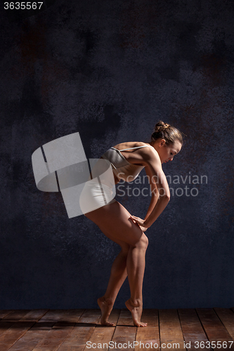 Image of Young beautiful dancer in beige swimwear dancing on lilac background