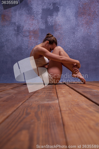 Image of Young beautiful dancer in beige swimwear dancing on lilac background