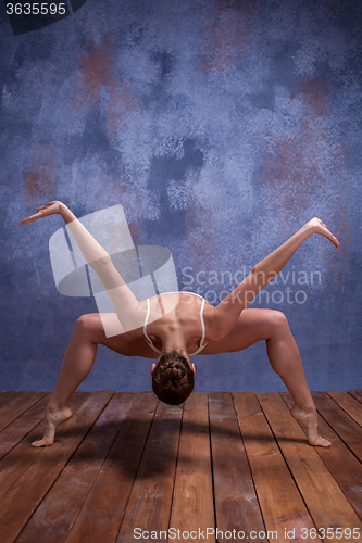 Image of Young beautiful dancer in beige swimwear dancing on lilac background