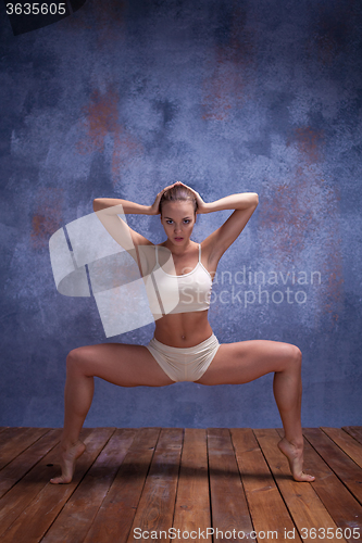 Image of Young beautiful dancer in beige swimwear dancing on lilac background