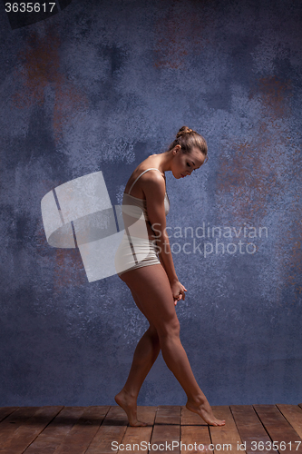 Image of Young beautiful dancer in beige swimwear dancing on lilac background