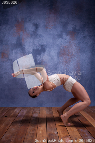 Image of Young beautiful dancer in beige swimwear dancing on lilac background