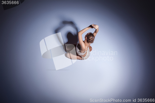 Image of Young beautiful dancer in beige swimwear dancing on lilac background