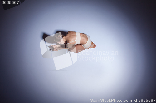 Image of Young beautiful dancer in beige swimwear dancing on lilac background