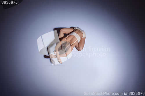 Image of Young beautiful dancer in beige swimwear dancing on lilac background