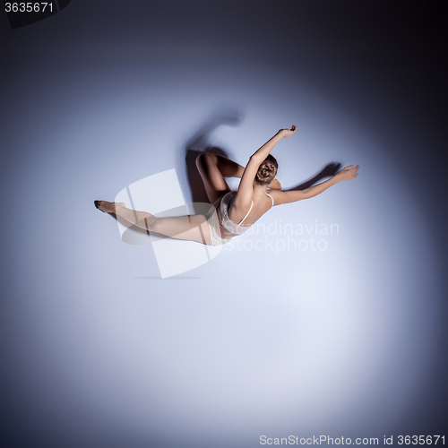 Image of Young beautiful dancer in beige swimwear dancing on lilac background