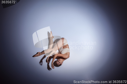 Image of Young beautiful dancer in beige swimwear dancing on lilac background