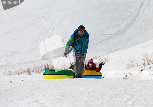 Image of Father and daughter with snow tube