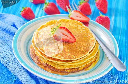 Image of pancakes on plate and fresh strawberries