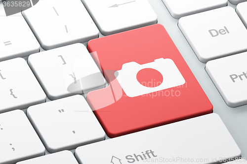 Image of Tourism concept: Photo Camera on computer keyboard background