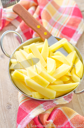 Image of raw potato in metal bowl