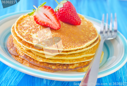 Image of pancakes on plate and fresh strawberries