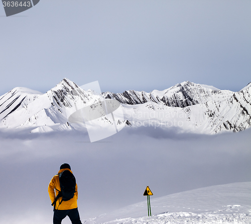 Image of Freerider on off-piste slope in mist and warning sing