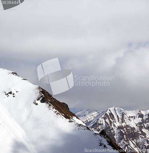 Image of Snowy slope and sky with clouds at sun day