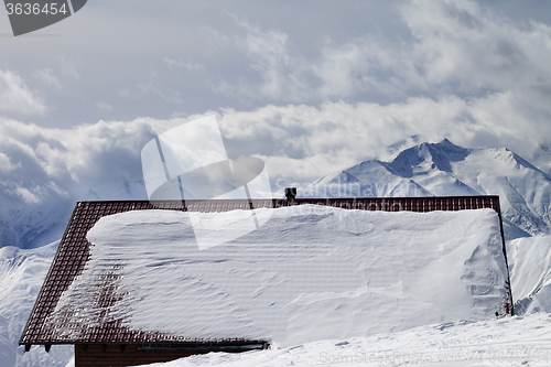 Image of Snowy roof and mountains in clouds
