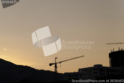 Image of construction cranes at sunset  