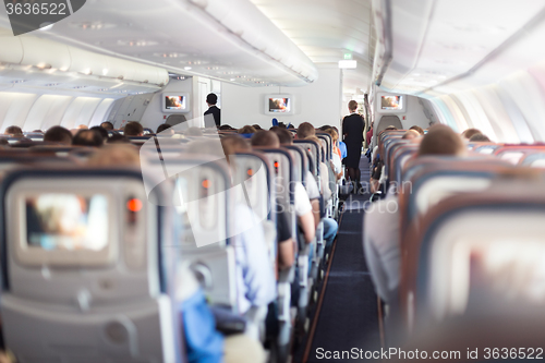 Image of Interior of airplane with passengers on seats.