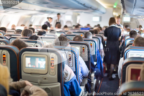 Image of Interior of airplane with passengers on seats.