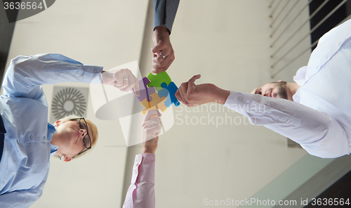 Image of business people group assembling jigsaw puzzle