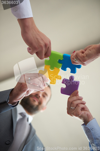 Image of business people group assembling jigsaw puzzle