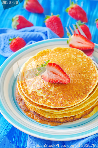 Image of pancakes on plate and fresh strawberries