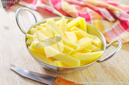 Image of raw potato in metal bowl